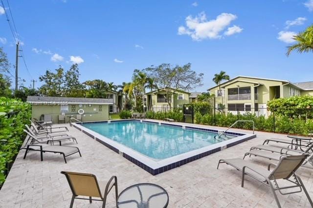 community pool featuring a patio area and fence