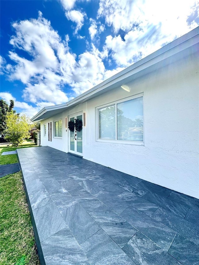 view of property exterior featuring stucco siding and french doors