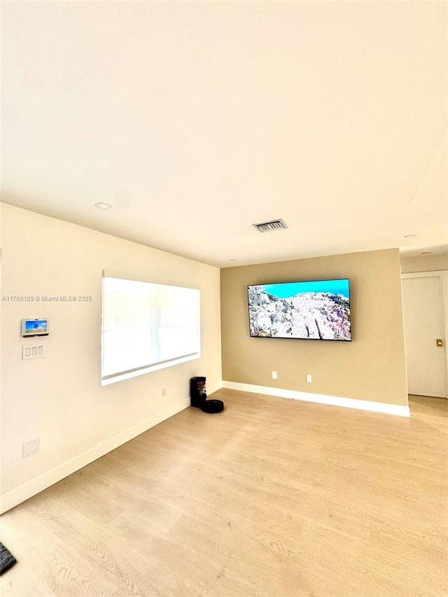 unfurnished living room with baseboards, visible vents, and light wood finished floors