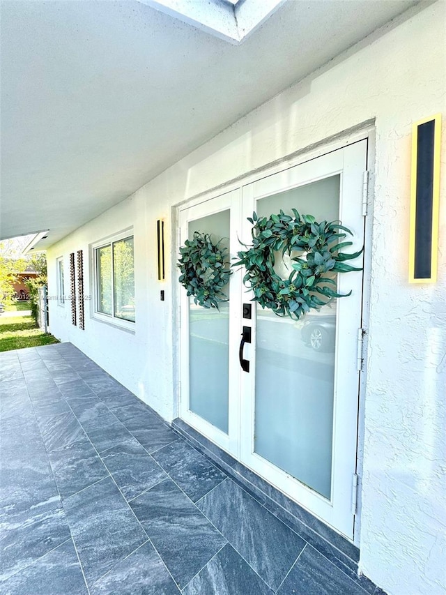 view of exterior entry featuring a patio area