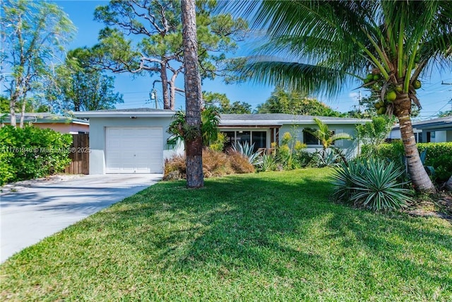 view of front of property featuring a front yard, fence, driveway, stucco siding, and a garage