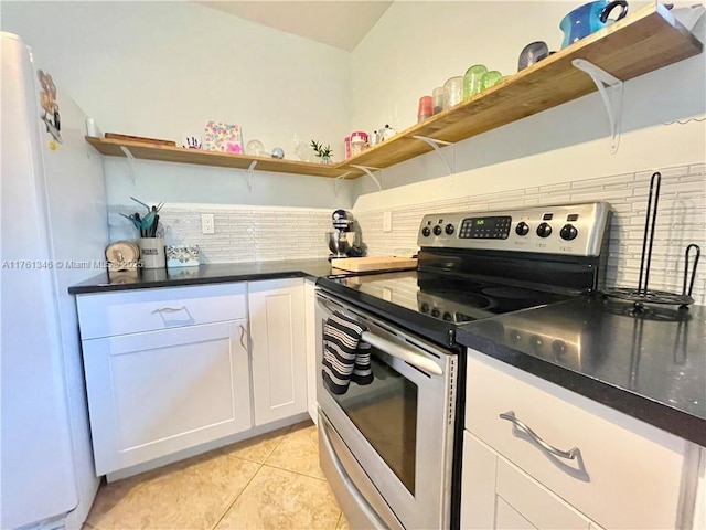 kitchen with open shelves, tasteful backsplash, white cabinetry, freestanding refrigerator, and stainless steel range with electric cooktop