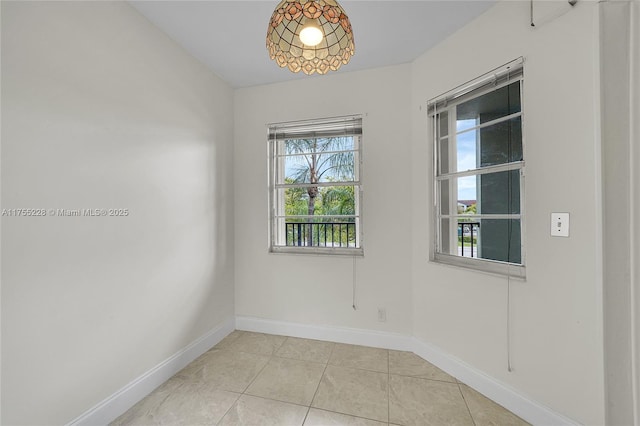 empty room featuring light tile patterned floors and baseboards