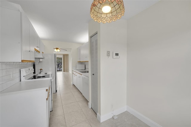 kitchen featuring light tile patterned floors, decorative backsplash, white appliances, and light countertops