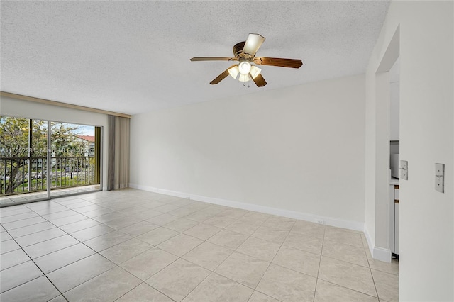 empty room featuring light tile patterned floors, a textured ceiling, baseboards, and a ceiling fan