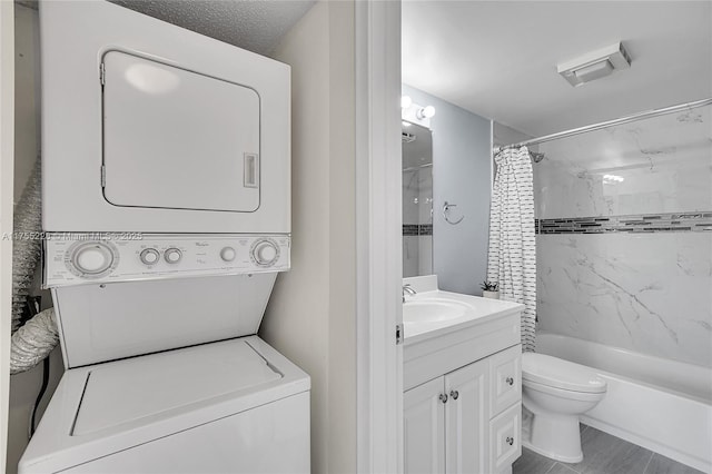 bathroom with stacked washer / drying machine, toilet, shower / bath combo, and vanity