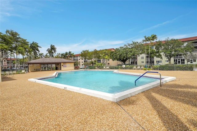 pool with a patio area and fence