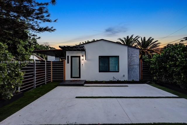 view of front of home featuring fence and stucco siding