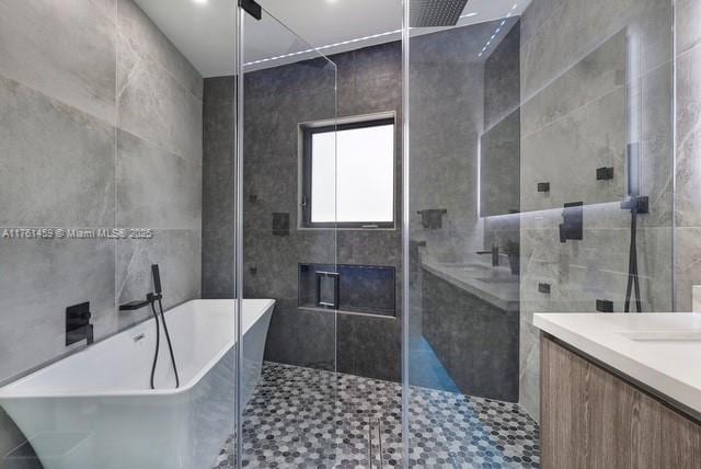 bathroom featuring vanity, a soaking tub, and a stall shower