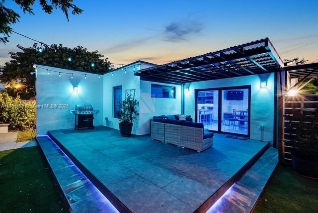 exterior space with stucco siding, an outdoor hangout area, a patio, and a pergola