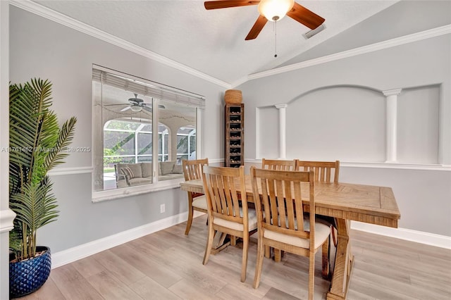 dining space featuring baseboards, wood finished floors, lofted ceiling, and ornamental molding