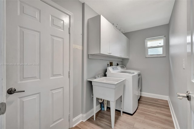 laundry area featuring baseboards, cabinet space, independent washer and dryer, and light wood finished floors