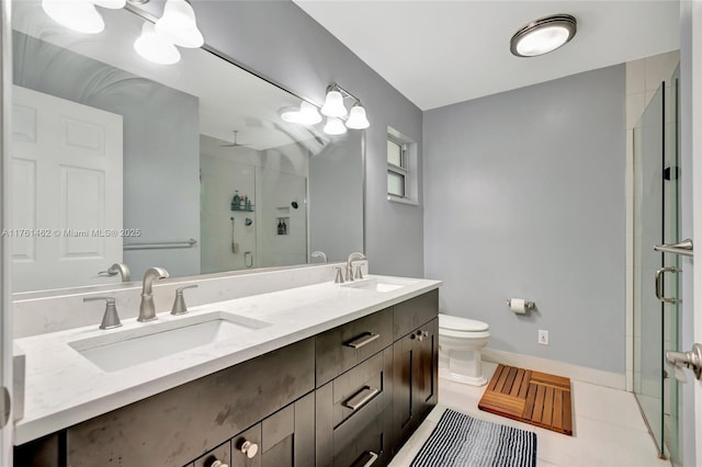 bathroom featuring double vanity, a stall shower, toilet, and a sink