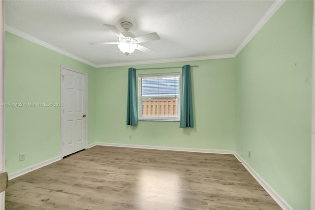 unfurnished room featuring ceiling fan, baseboards, wood finished floors, and ornamental molding