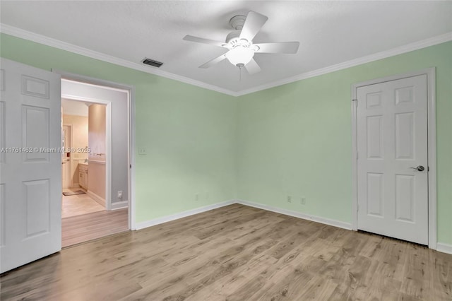 unfurnished bedroom with visible vents, ornamental molding, and light wood finished floors