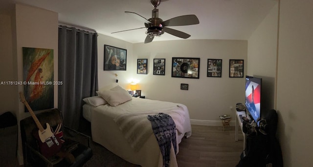 bedroom featuring a ceiling fan, baseboards, and wood finished floors