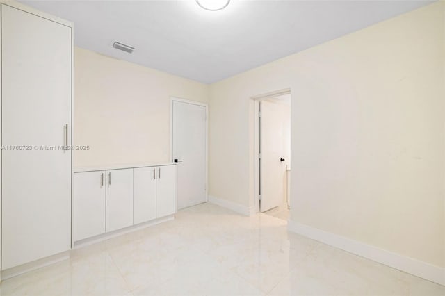 unfurnished room featuring visible vents and baseboards