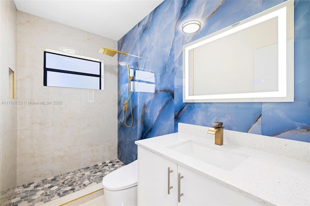 bathroom featuring tiled shower, toilet, and vanity