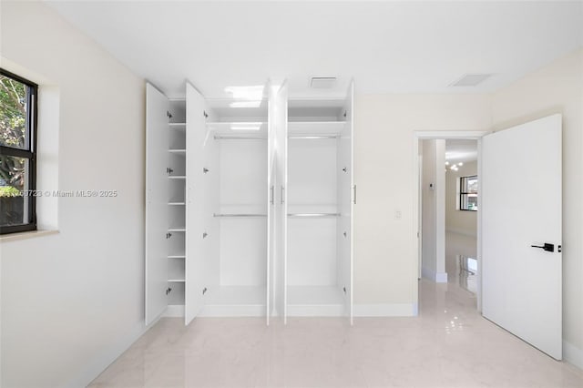 unfurnished bedroom with visible vents, a closet, and baseboards