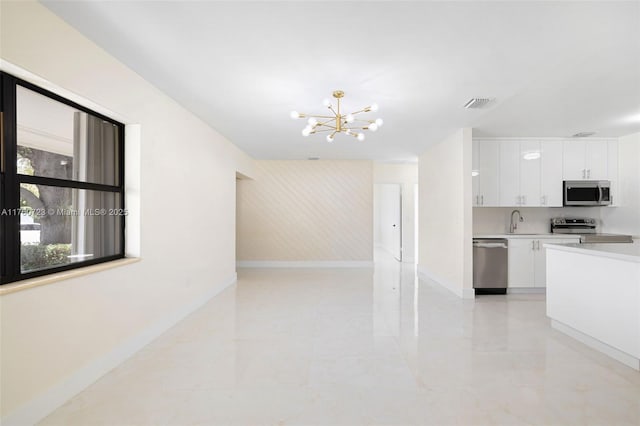 kitchen featuring visible vents, a sink, appliances with stainless steel finishes, white cabinets, and light countertops