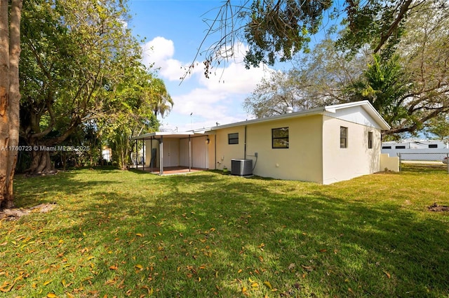 rear view of property with central air condition unit, a lawn, stucco siding, a fenced backyard, and a patio