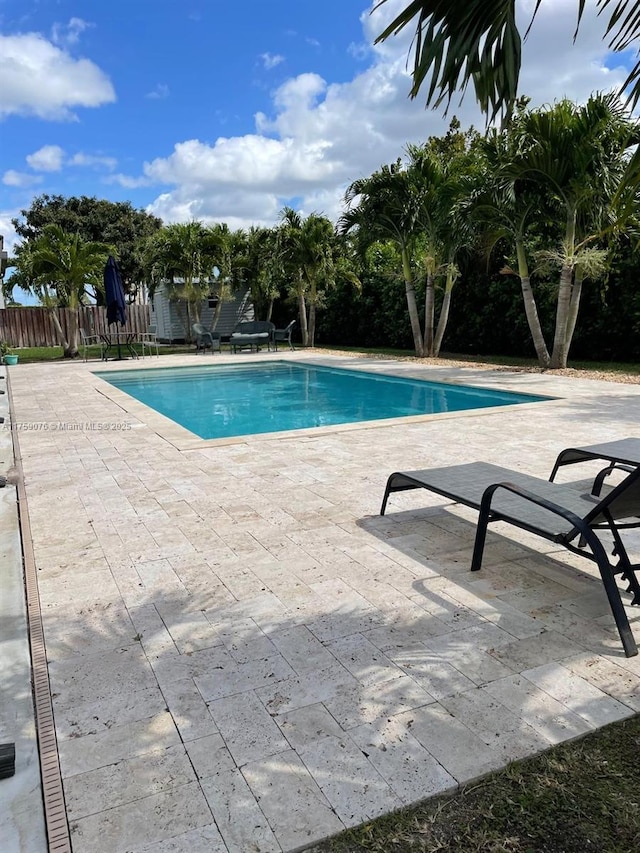 view of swimming pool with a patio, fence, and a fenced in pool