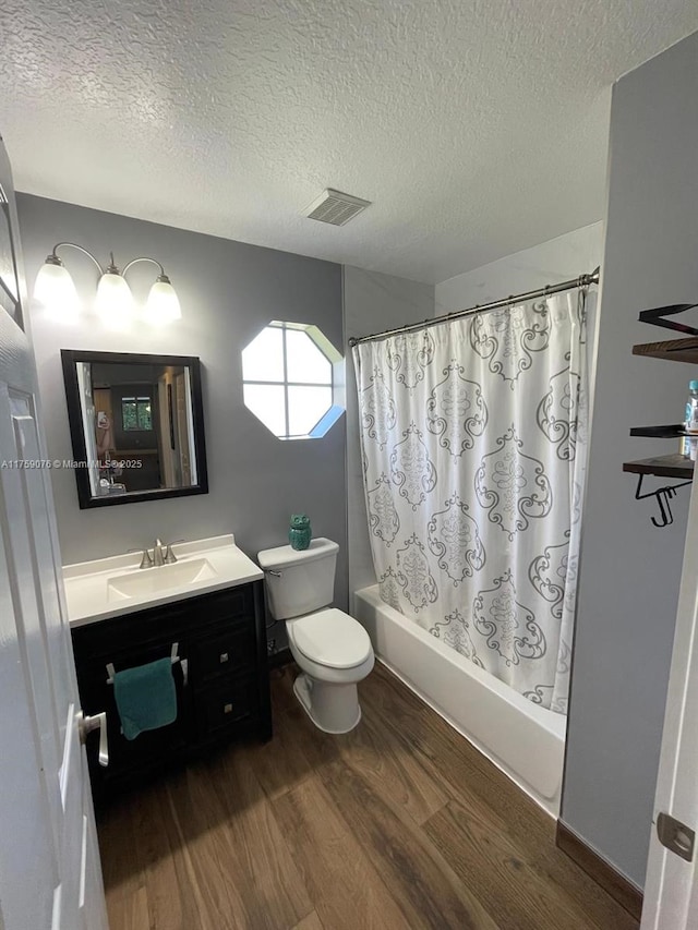 full bathroom with visible vents, shower / tub combo with curtain, toilet, wood finished floors, and vanity