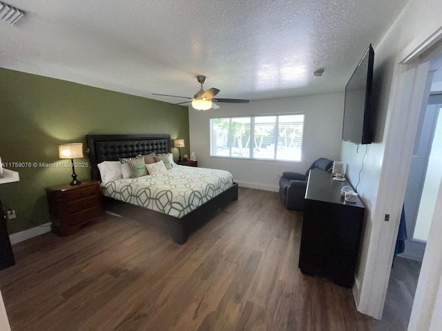 bedroom featuring visible vents, a textured ceiling, a ceiling fan, and wood finished floors