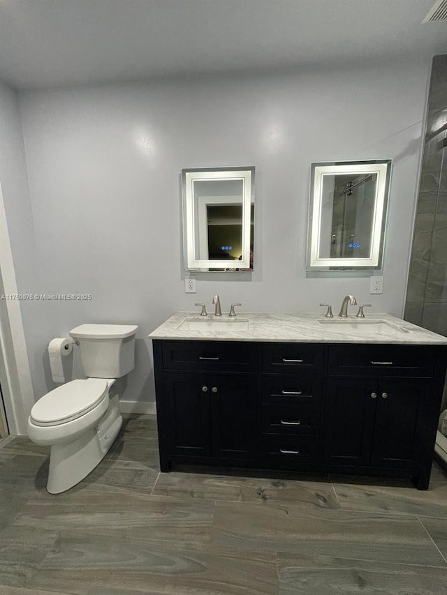 bathroom with double vanity, toilet, and a sink