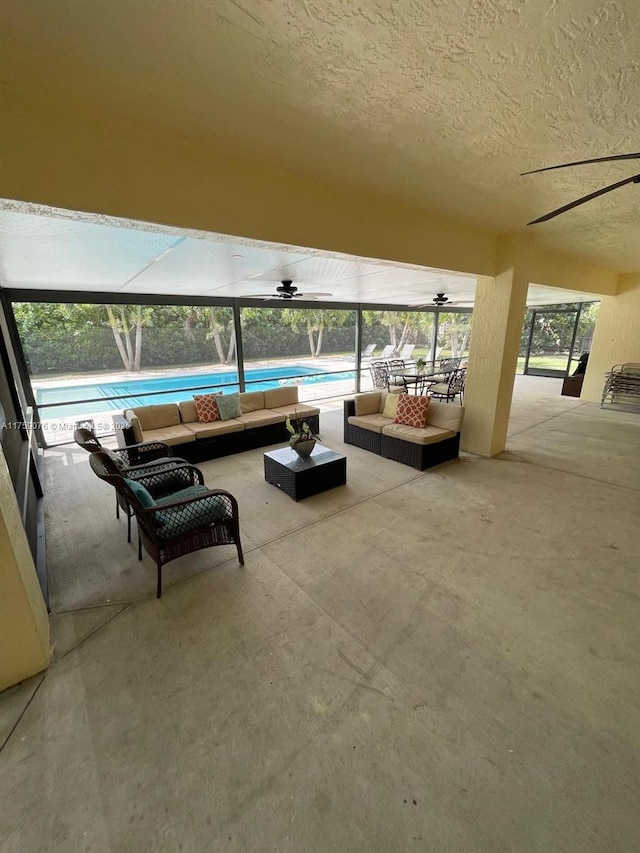 view of patio / terrace featuring an outdoor living space, an outdoor pool, and a lanai