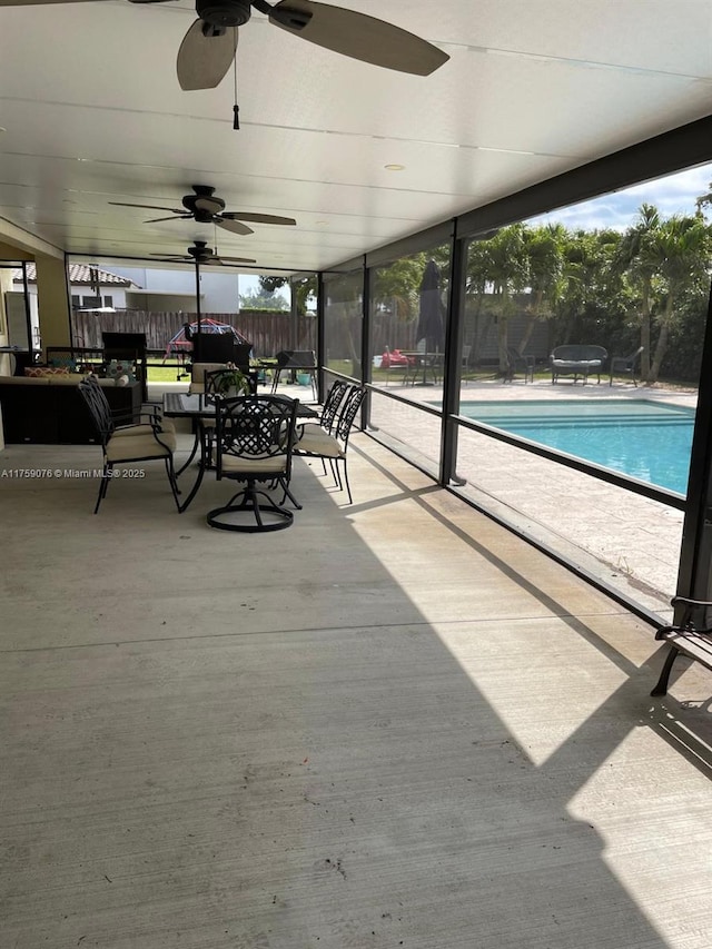 view of patio with glass enclosure, a community pool, a ceiling fan, and fence