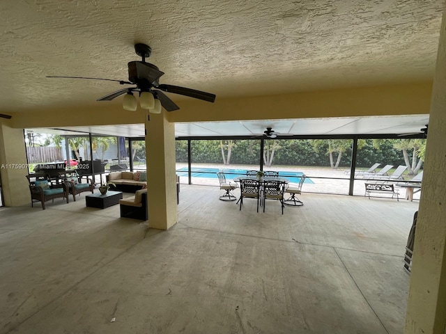 view of patio / terrace featuring an outdoor living space, glass enclosure, a community pool, and ceiling fan