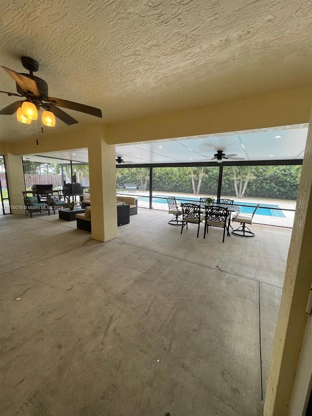 view of patio / terrace featuring glass enclosure, an outdoor pool, outdoor lounge area, and ceiling fan