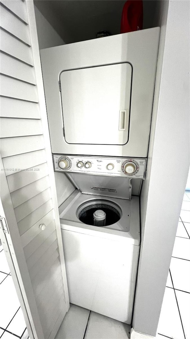 laundry area featuring tile patterned flooring, laundry area, and stacked washer / dryer