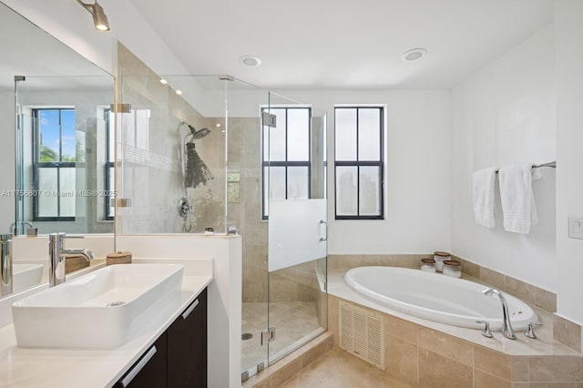 bathroom with visible vents, a shower stall, tile patterned flooring, a bath, and vanity