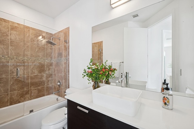 bathroom featuring vanity, toilet, visible vents, and bath / shower combo with glass door