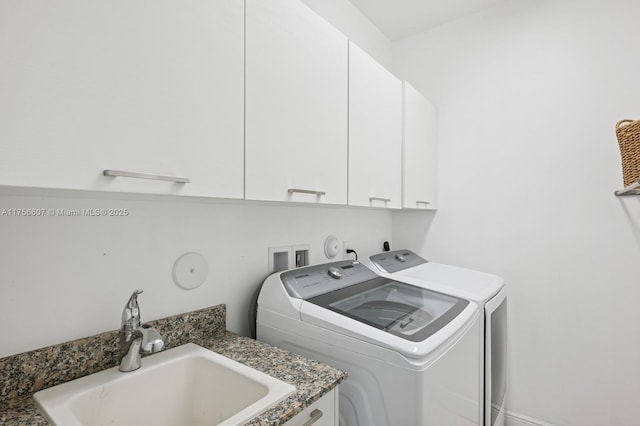 washroom featuring a sink, cabinet space, and independent washer and dryer