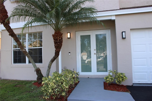 view of exterior entry with french doors and stucco siding