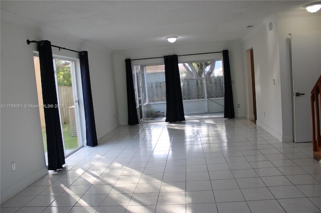 unfurnished room featuring crown molding, light tile patterned flooring, and baseboards