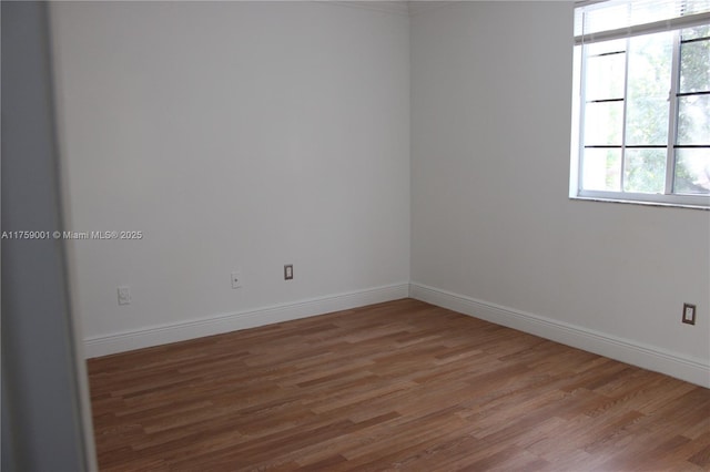 unfurnished room featuring baseboards and wood finished floors