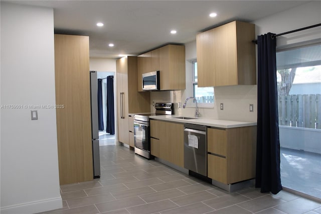 kitchen featuring light brown cabinets, appliances with stainless steel finishes, and modern cabinets