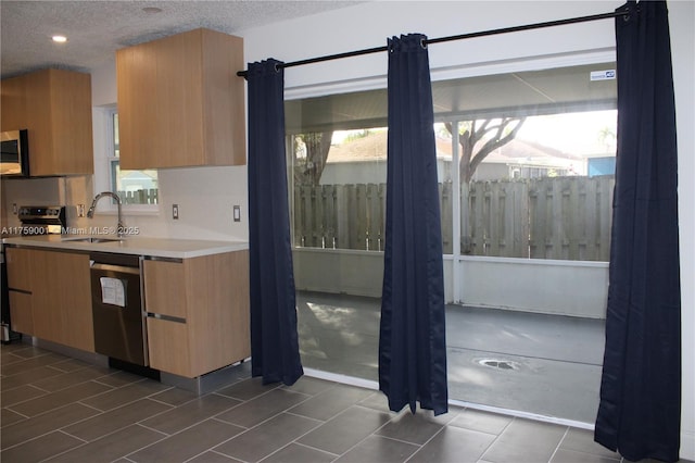 kitchen with dishwashing machine, a sink, range with electric cooktop, a textured ceiling, and stainless steel microwave