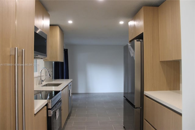 kitchen with modern cabinets, a sink, recessed lighting, appliances with stainless steel finishes, and light countertops