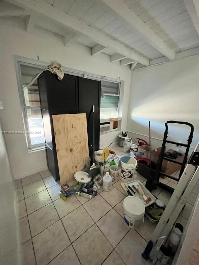 kitchen featuring light tile patterned floors, beam ceiling, and plenty of natural light