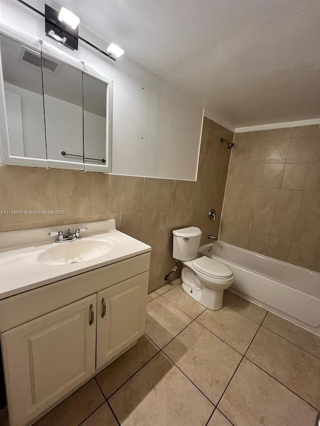 bathroom with tile patterned floors, visible vents, toilet, tile walls, and bathtub / shower combination