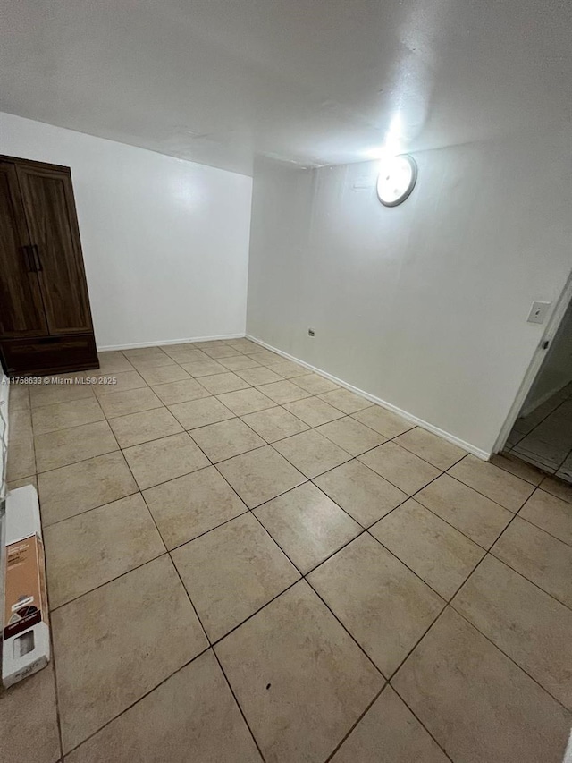 unfurnished room featuring light tile patterned floors and baseboards