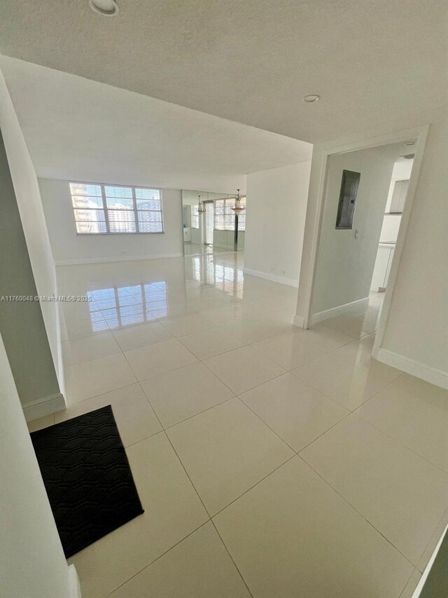 empty room featuring light tile patterned floors and baseboards