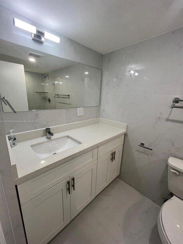 bathroom with visible vents, marble finish floor, toilet, and vanity