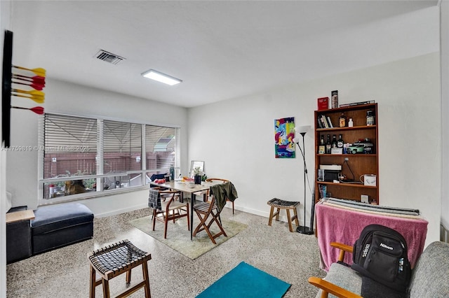 interior space with visible vents, baseboards, and speckled floor