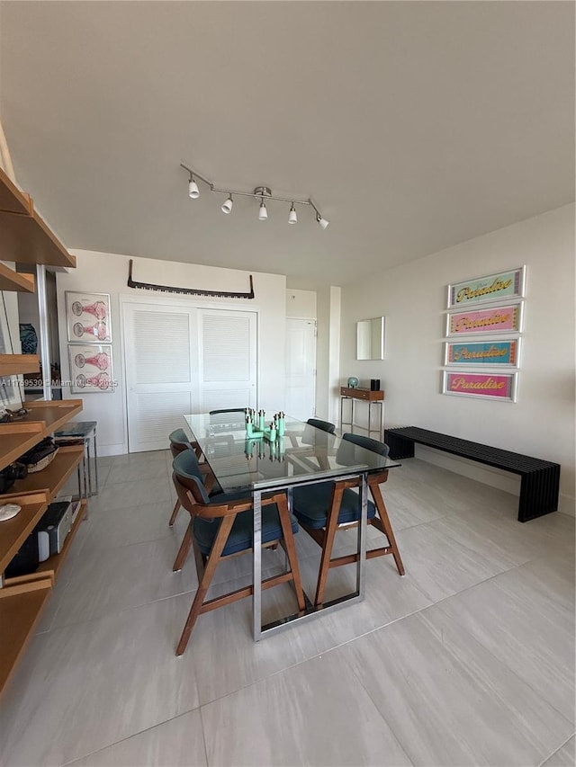 dining room featuring tile patterned floors and rail lighting